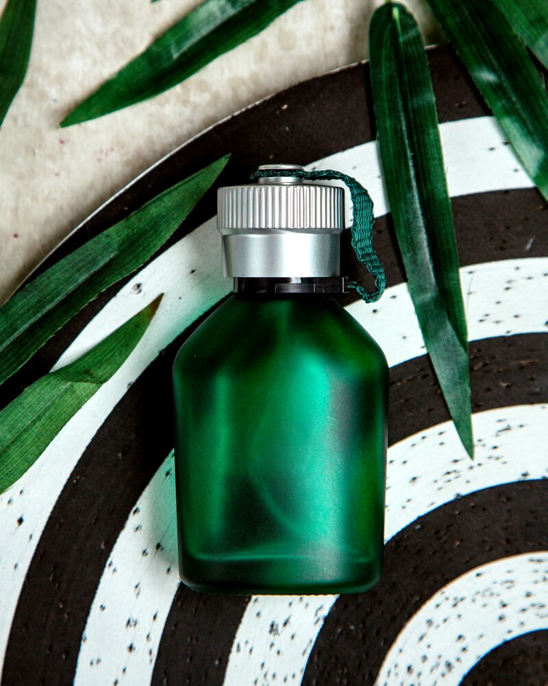 Green bottle of parfum on the table
